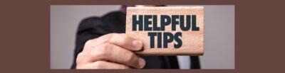 Dark brown background. Gray background inside with the torso of a man in a dark suit, right arm outstretched holding a light brown wood block with HELPFUL TIPS in black bold letters.